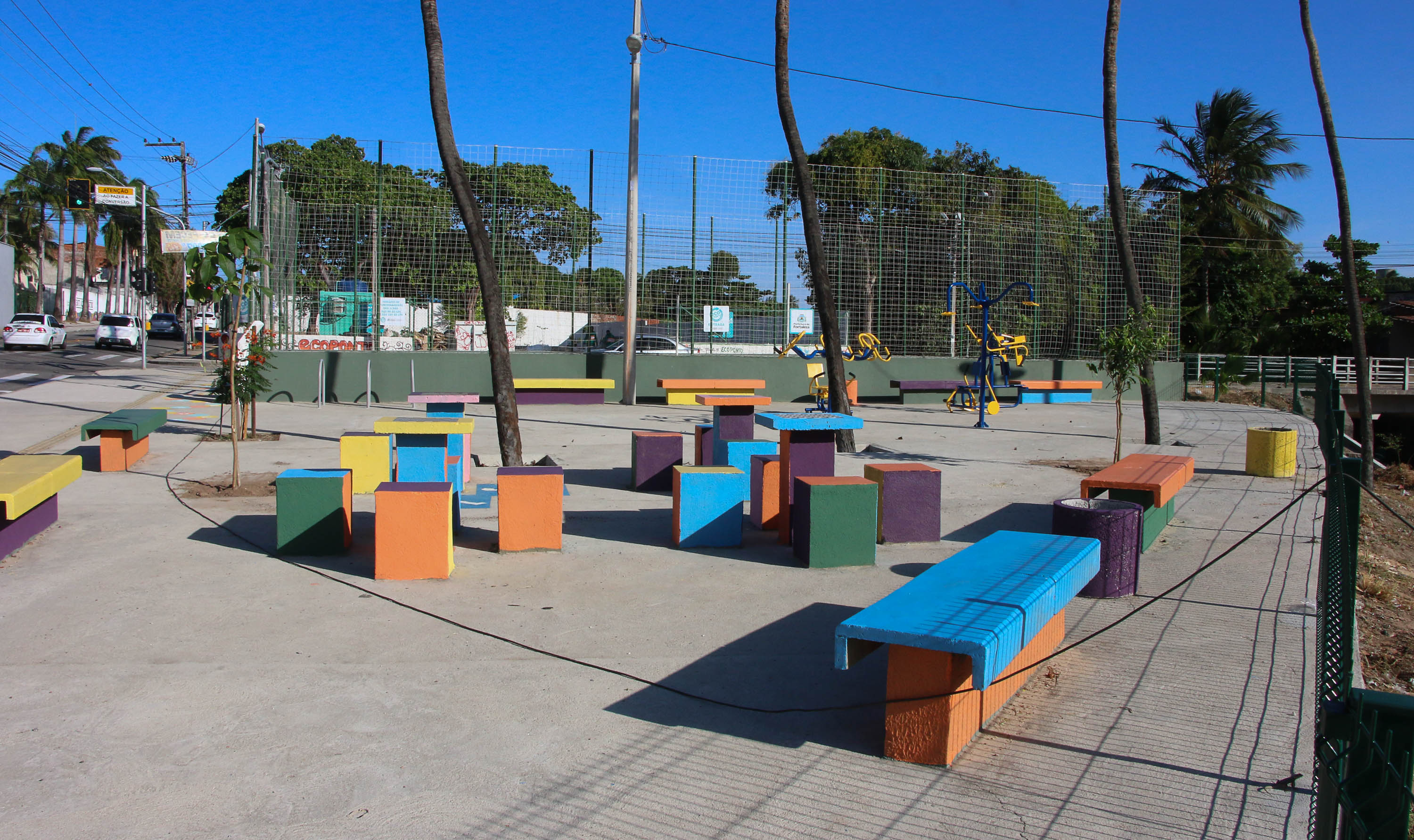 a foto mostra bancos coloridos no micro parque